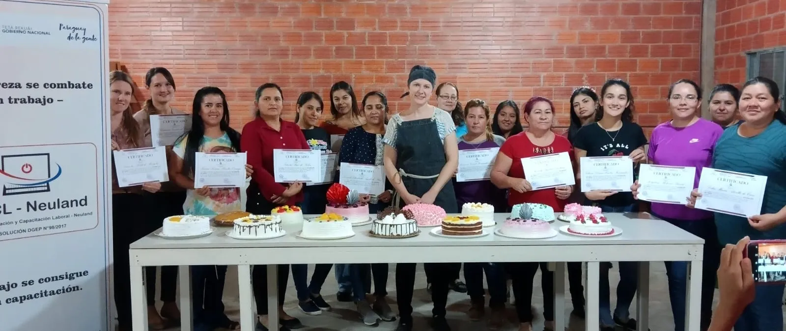 Egresadas del curso de repostería con sus tortas